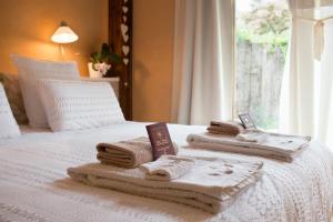 ein weißes Bett mit Handtüchern und einem Fenster in der Unterkunft Absolut Oiseaux in Parisot