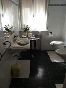 タビアーノにあるAlbergo Delle Fontiの白いバスルーム(洗面台、トイレ付)
