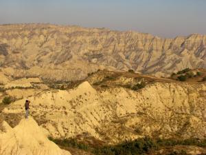 een persoon die bovenop een berg staat en naar de bergen kijkt bij Colourful Udabno in Udabno
