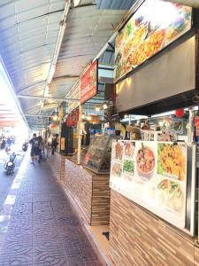 a food stand in a market with food on display at Bangkok Sanookdee Hostel in Bangkok