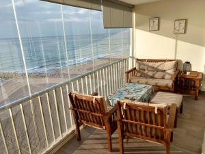 - un balcon avec des chaises et un canapé donnant sur l'océan dans l'établissement Bellavista apartment, à El Campello