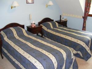 3 camas en un dormitorio con paredes azules en The Prince's House Hotel en Glenfinnan