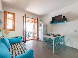 a living room with a blue couch and a table at Sardinia SPA Apartment in Geremèas