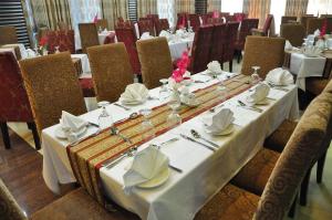 ein langer Tisch mit weißen Tischdecken und Servietten in der Unterkunft Marino Hotel - Best near Airport in Dhaka