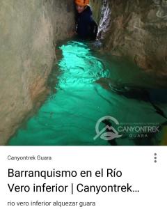 een man in een grot naast een rivier bij Carmen De Arnas in Colungo