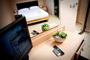 Habitación con TV y dormitorio con cama. en Crystal Bay Hotel en Kissamos