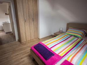 Un dormitorio con una cama con mantas de colores. en Apartment Marjetka en Žirovnica