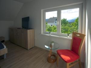 Sala de estar con ventana, silla y mesa en Apartment Marjetka, en Žirovnica