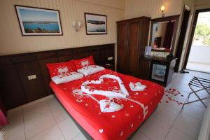 a bedroom with a red bed with mice on it at Ezer Hotel in Ayvalık