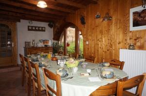 een eetkamer met een lange tafel met stoelen en een tafelkleed bij Auberge du Thiollet in Montromant