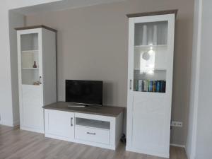 Zimmer mit einem Schreibtisch, einem TV und einer Tür in der Unterkunft Ferienwohnung an der Kimbach 1 in Bad König