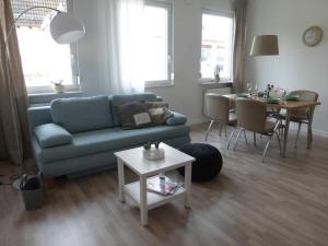 ein Wohnzimmer mit einem blauen Sofa und einem Tisch in der Unterkunft Ferienwohnung an der Kimbach 1 in Bad König