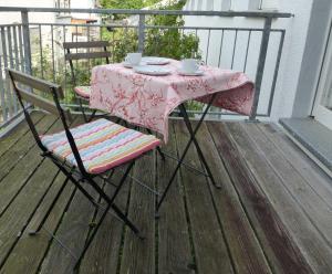 バート・ケーニヒにあるFerienwohnung an der Kimbach 2のテーブル、椅子、バルコニー(ピンクのテーブルクロス付)