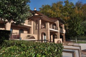 Casa de ladrillo grande con balcón en Carpediem Assisi Living Club, en Piano Delle Pieve