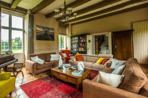 a living room with couches and a piano at Capitainerie Clos Morin in Saint Malo