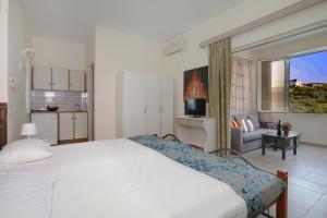 a bedroom with a bed and a living room at El Greco Studios in Agia Marina Nea Kydonias