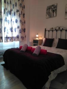 a bedroom with a large bed with two pillows on it at D&Heart and Soul of Granada in Granada