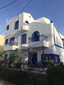 un gran edificio blanco con puertas y ventanas azules en Psaras Apartments, en Stalida