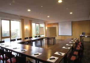 Klostergasthof Roggenburg في Roggenburg: قاعة اجتماعات كبيرة مع طاولة وكراسي كبيرة