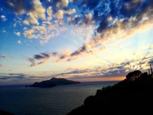 a sunset over a body of water with a mountain at Acquamarina Accommodation in Massa Lubrense