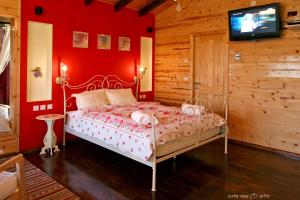 a bedroom with a bed with a red wall at Villa Romantica in Ani'am