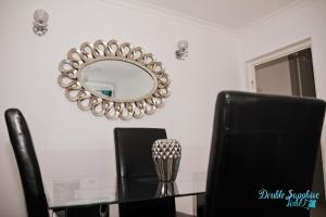 a dining room table with black chairs and a mirror at Apartment Double Sapphire Time in Łódź