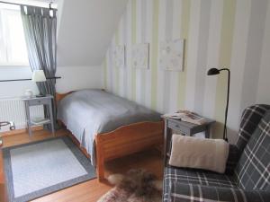 ブランケンハイムにあるEIFEL Gästewohnungのベッドルーム1室(ベッド1台、ソファ、椅子付)