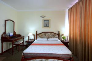 sypialnia z łóżkiem i biurkiem oraz łóżko o wymiarach 6 x 6 x 6 w obiekcie Hoang Ha Hotel w Ho Chi Minh
