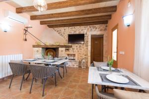 a dining room with a table and chairs and a fireplace at Finca - Agroturisme Sa Parellada in Binibona