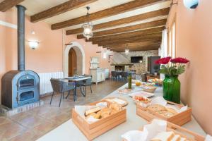 a living room with a table with food and a stove at Finca - Agroturisme Sa Parellada in Binibona