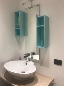 uma casa de banho com um lavatório branco e um espelho. em Il Nido da Chiara em La Spezia