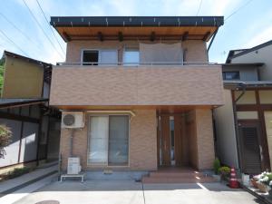 une maison avec un balcon au-dessus dans l'établissement Utatei Villa, à Takayama