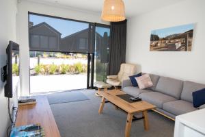 a living room with a couch and a table at Cherry Apartment in Queenstown