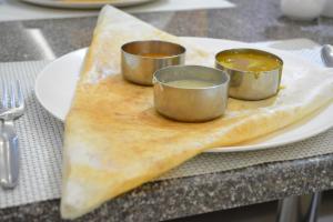 a plate with three small cups on top of a calzone at Star MSR Residency in Perambalūr