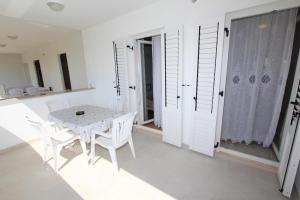 biała jadalnia z białym stołem i krzesłami w obiekcie Apartments Palaziol w Rovinj