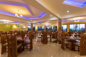 a restaurant with wooden tables and chairs and windows at Epashikino Resort & Spa in Gilgil