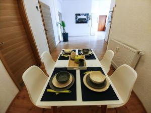 a dining room table with a black and white table and chairs at Pension BeOne in Trossingen