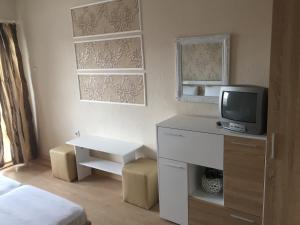 a small room with a bed and a tv at Guest House Gloria in Nesebar