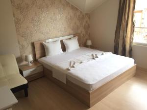 a bedroom with a bed and a chair and a window at Guest House Gloria in Nesebar