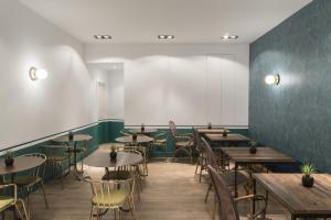 a restaurant with tables and chairs and a wall at Petit Palace Canalejas Sevilla in Seville