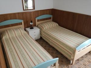 una camera con due letti, un tavolo e una sedia di Villa Pellarini a Lignano Sabbiadoro