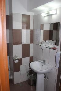 a bathroom with a sink and a toilet at Hotel Ciucas in Vălenii de Munte