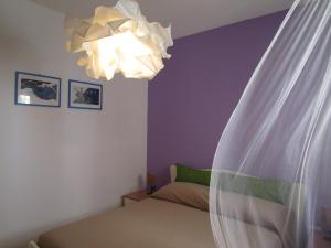 シラクーサにあるIl volo di Pindaroのベッドルーム1室(ベッド1台、シャンデリア付)