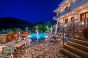 a patio of a house with a blue table and chairs at Hotel Eirini in Gliki