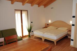 sypialnia z łóżkiem i zielonym krzesłem w obiekcie Agritur alla Veduta w Trydencie