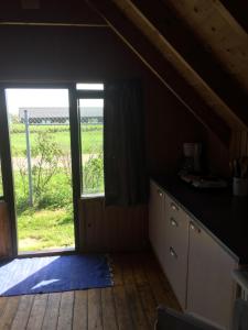 a kitchen with a large window with a view of a field at Løkken Strand Camping in Løkken