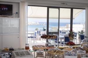 a table with food on it with a view of the ocean at Hotel Albània in Otranto