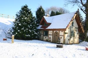 a small house with a snow covered roof in the snow at Coynant Farm Guesthouse - Farm Park Stay in Swansea