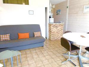 een woonkamer met een bank en een tafel en stoelen bij Rozenn in Sarzeau