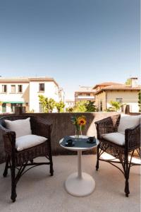 two chairs and a table with a vase of flowers on a patio at Esclusivo appartamento- 6 persone in Villa Liberty in Venice-Lido